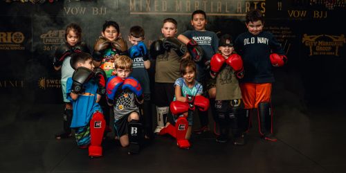 A group of young children posing in a martial arts gym