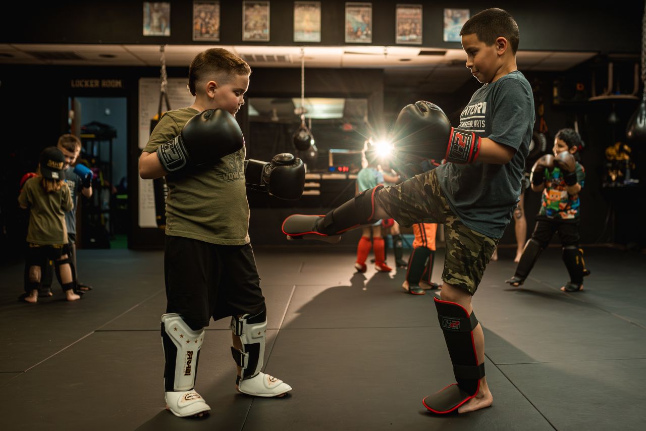 Two young boys practicing martial arts in a gym