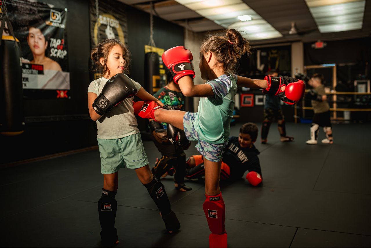 Two young girls practicing martial arts in a gym