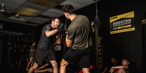 Two men sparring in a martial arts gym