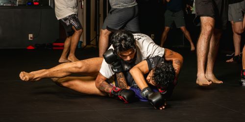 Two men engaged in a grappling session during a martial arts training session.